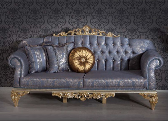 Sophisticated classic sofa in Chesterfield design for the living room with golden cushions.