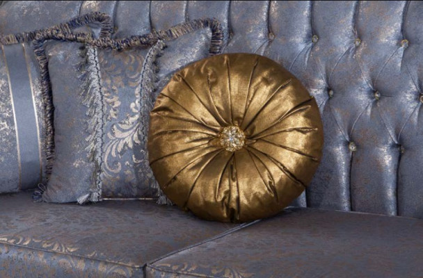Sophisticated classic sofa in Chesterfield design for the living room with golden cushions.