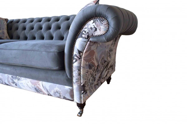 A striking three-seater sofa in Chesterfield design with delicate gray floral decoration.