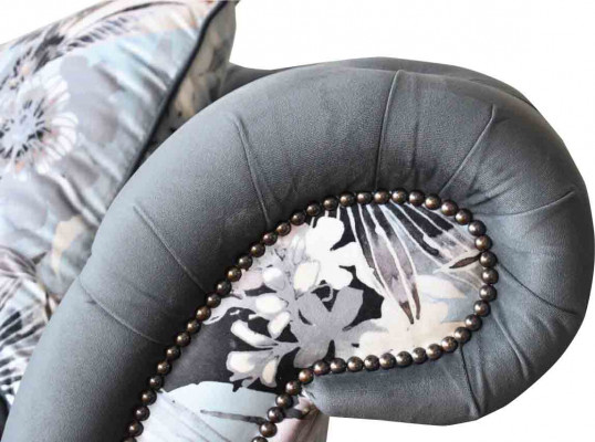 A striking three-seater sofa in Chesterfield design with delicate gray floral decoration.