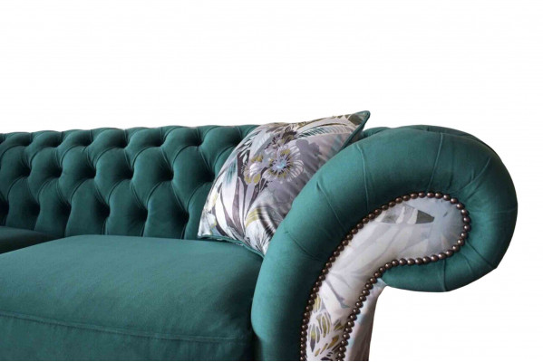 A lively three-seater Chesterfield sofa in a delicate emerald color with a floral pattern.