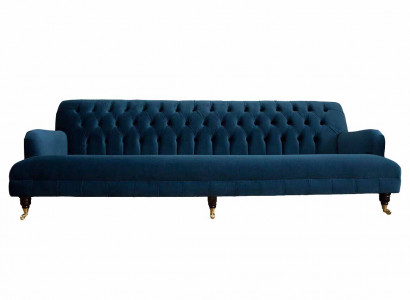Luxurious designer sofa in Chesterfield style with four seats in blue color.