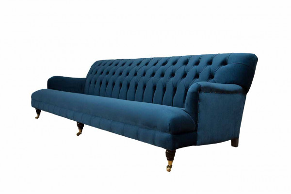 Luxurious designer sofa in Chesterfield style with four seats in blue color.