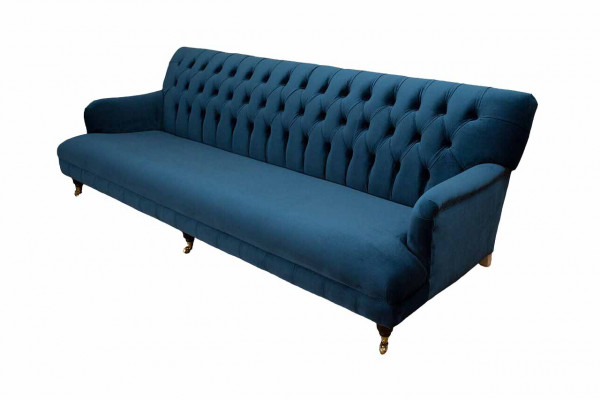 Luxurious designer sofa in Chesterfield style with four seats in blue color.