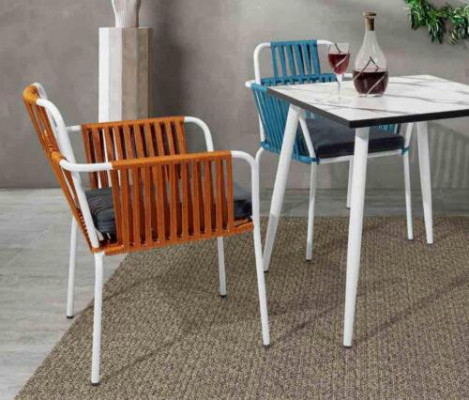Original chair in light color on white legs with a soft seat cushion made of stainless steel.