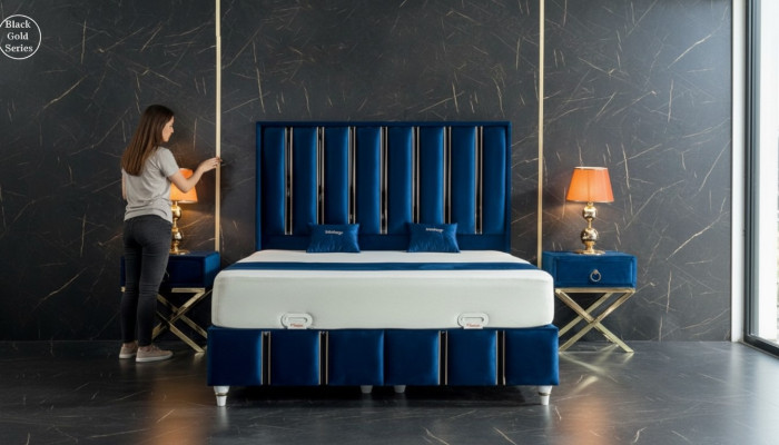 Sapphire blue designer bed with nightstands on gilded steel legs.