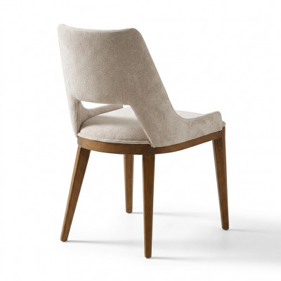 A laconic, modern chair with high wooden legs and upholstery in a pleasant, light cream color for the dining room.
