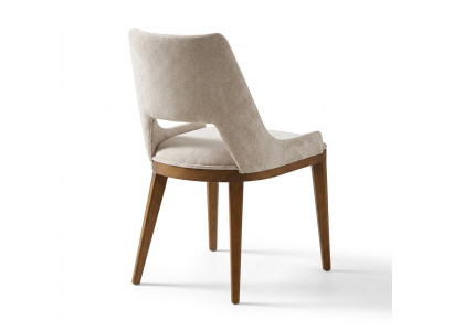 A laconic, modern chair with high wooden legs and upholstery in a pleasant, light cream color for the dining room.