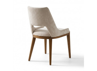 A laconic, modern chair with high wooden legs and upholstery in a pleasant, light cream color for the dining room.