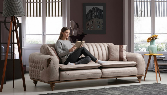 Beige three-seater Chesterfield couch, upholstered furniture, textile sofas, fabric.