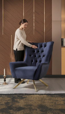 Luxurious blue Chesterfield armchair with velvet upholstery for the living room