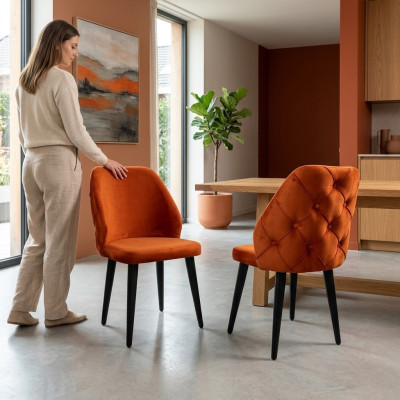 Padded orange Chesterfield wooden chair on black legs the dining room