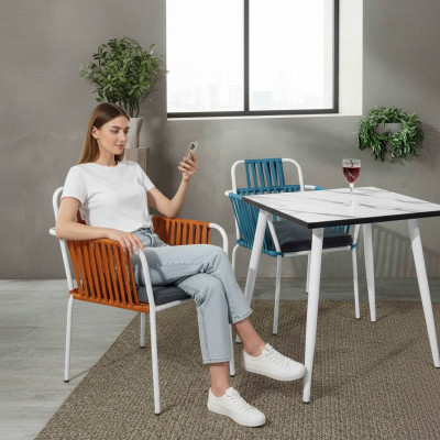 Original chair in light color on white legs with a soft seat cushion made of stainless steel.