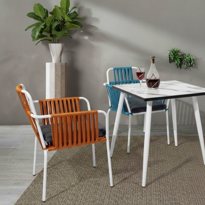 Original chair in light color on white legs with a soft seat cushion made of stainless steel.