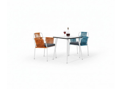 Original chair in light color on white legs with a soft seat cushion made of stainless steel.