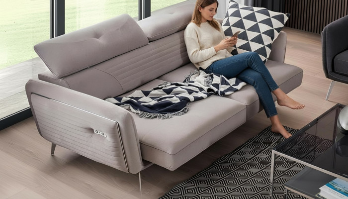 Luxurious, fashionable two-seater sofa with fabric upholstery on high legs