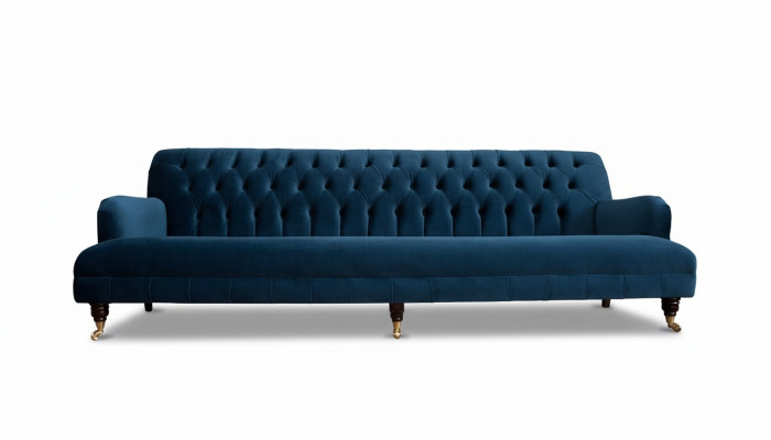 Luxurious designer sofa in Chesterfield style with four seats in blue color.