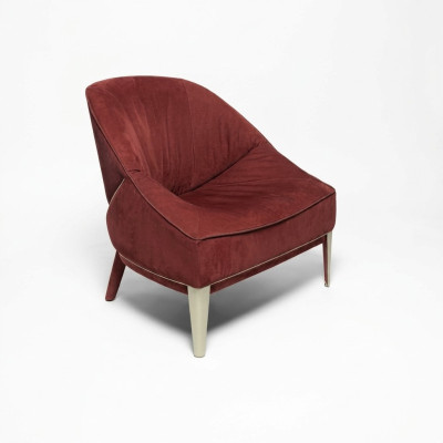 Red designer armchair with wooden legs, upholstered single-seater for living room furniture.